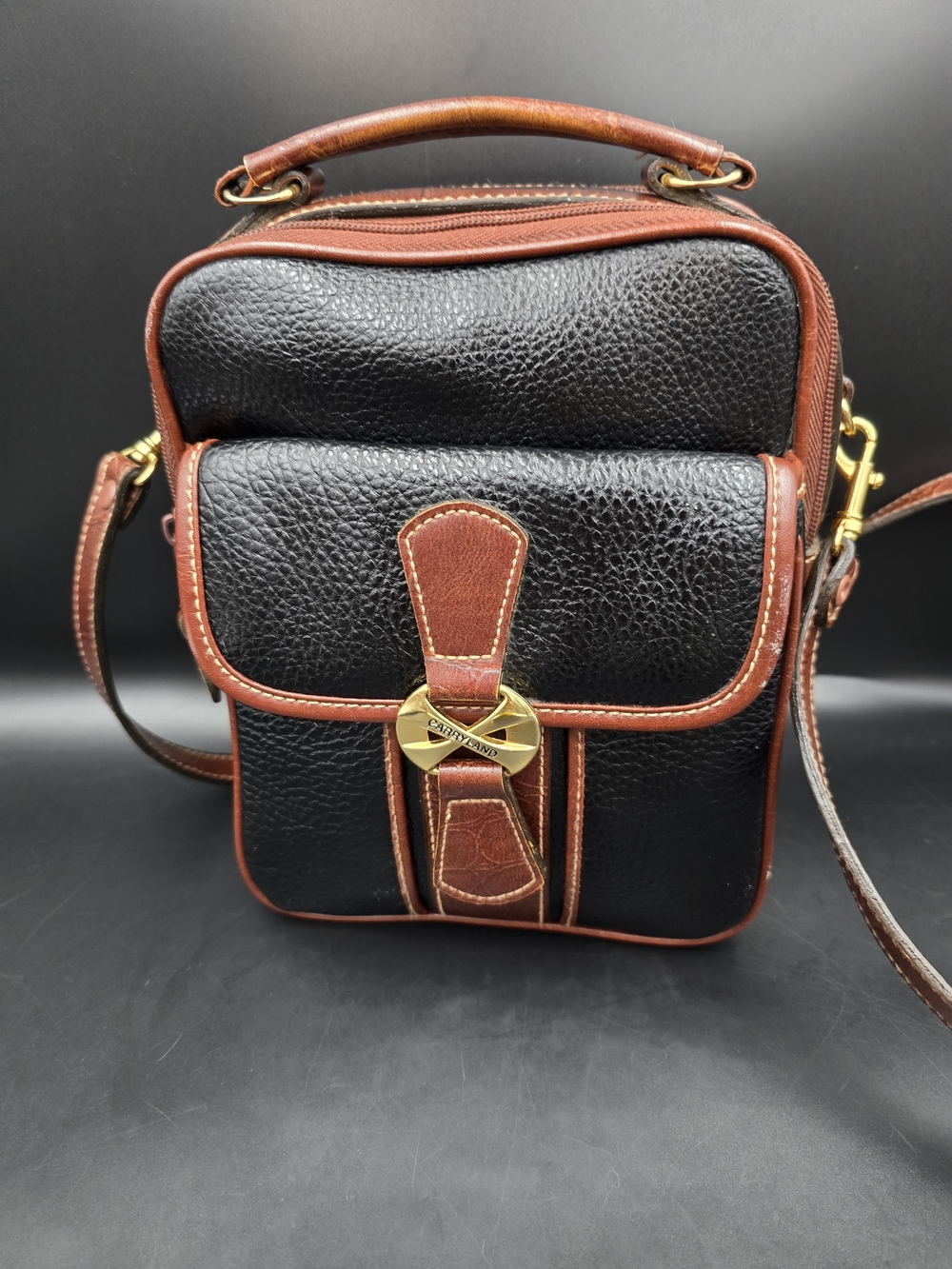Black Pebbled Crossbody Bag with Brown Trim and Gold Accent